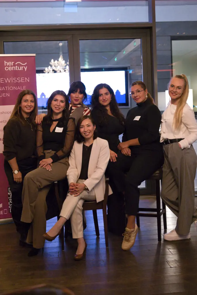 Teilnehmerinnen des HerCentury-Netzwerks sitzen und lächeln gemeinsam nach einer inspirierenden Veranstaltung.